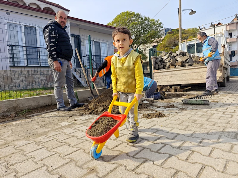 Küçük çocuk oyuncak el arabası ile belediye işçilerine yardım etti