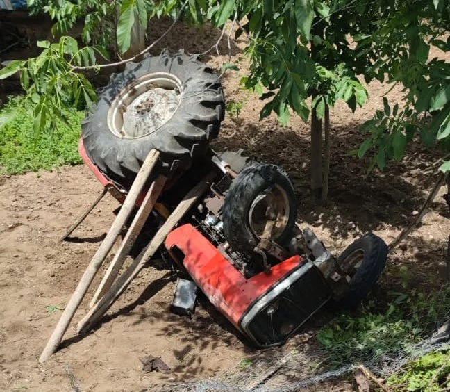 Devrilen traktörünün altında kalan sürücü, yaralandı 